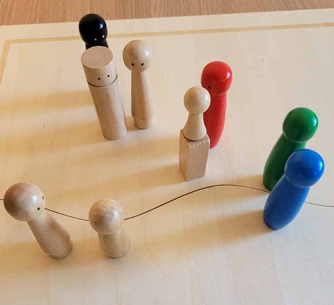 Holzfiguren in verschiedenen Farben symbolisieren einzelne Personen des familiären Umfeldes